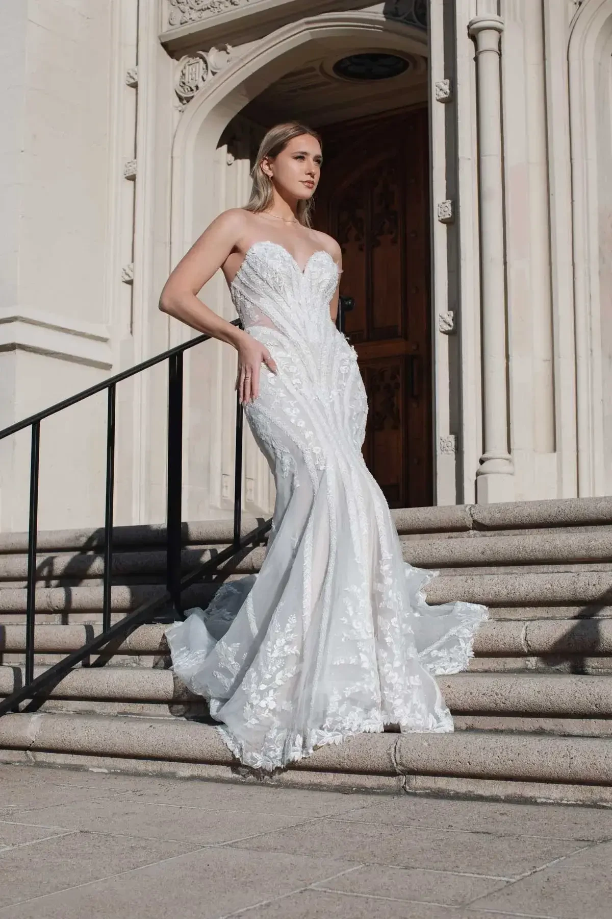Model is wearing a lace and tulle fit and flare strapless bridal gown with a sweetheart neckline