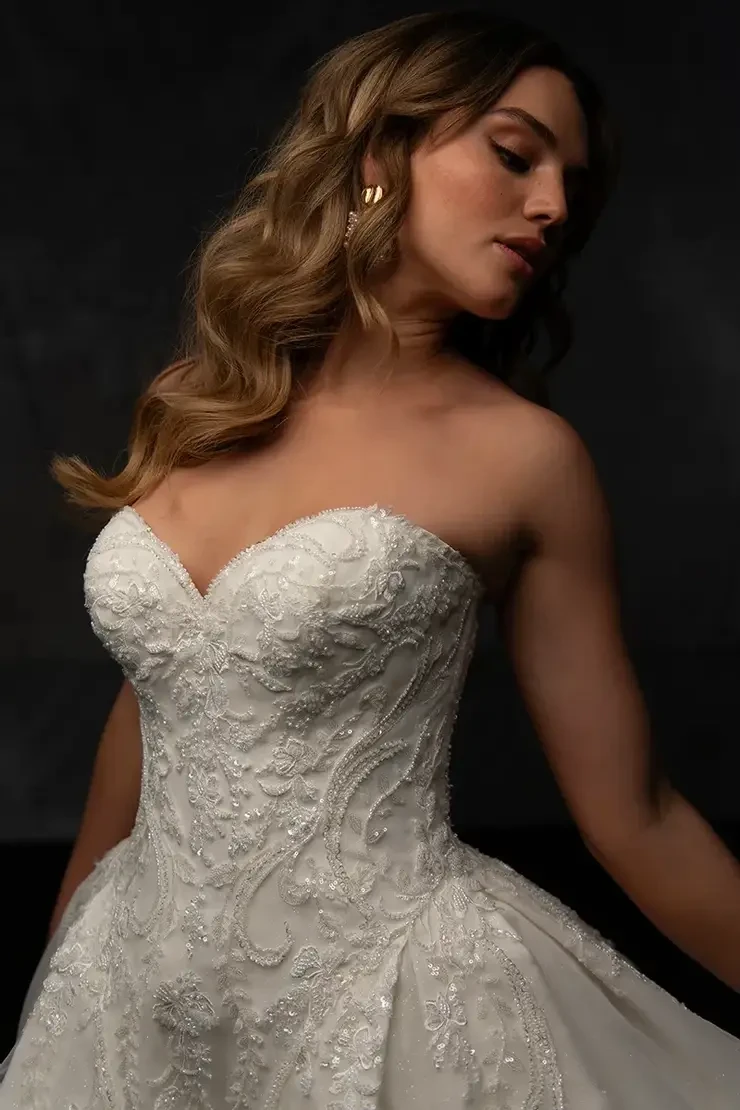Model is wearing a ball gown wedding dress with an embellished sweetheart bodice and shimmery glitter tulle skirt
