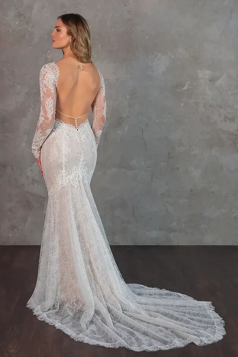 model is wearing a long sleeve lace bridal gown with an open back