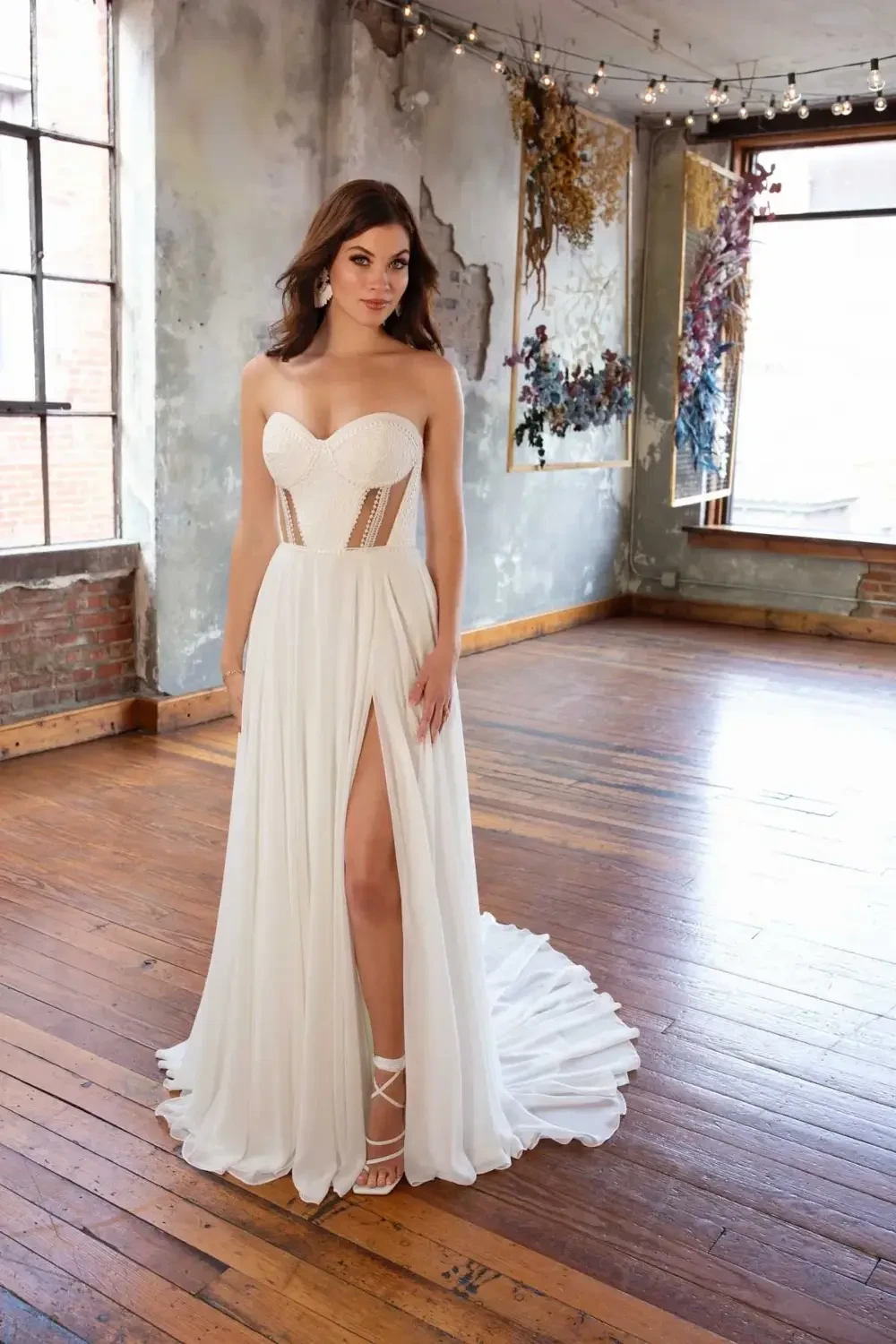 model is wearing a strapless a-line bridal gown with cutouts and detachable sleeves