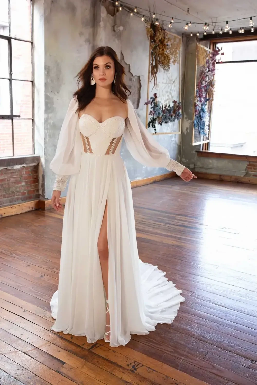 model is wearing a strapless a-line bridal gown with cutouts and detachable sleeves