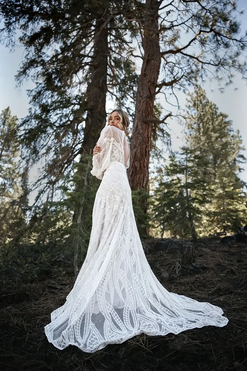 model is wearing a long sleeve boho wedding gown
