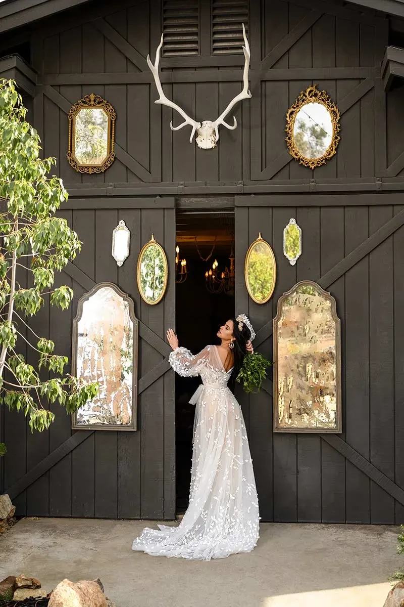 Model is wearing an A-line wedding dress with organic lace leaf and floral motifs, a strapless sweetheart neckline, and an optional matching jacket.
