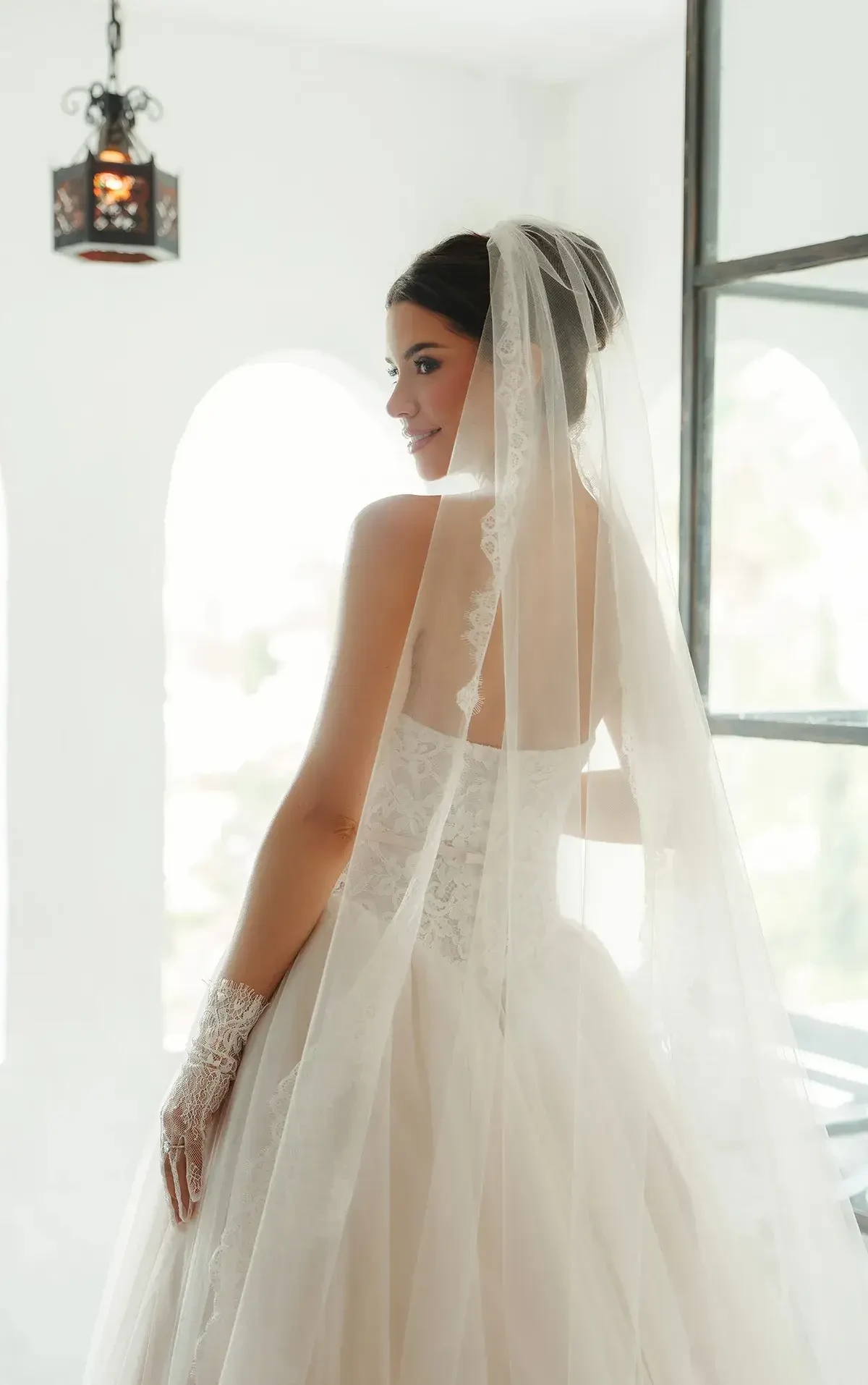 model is wearing a lace strapless ball gown