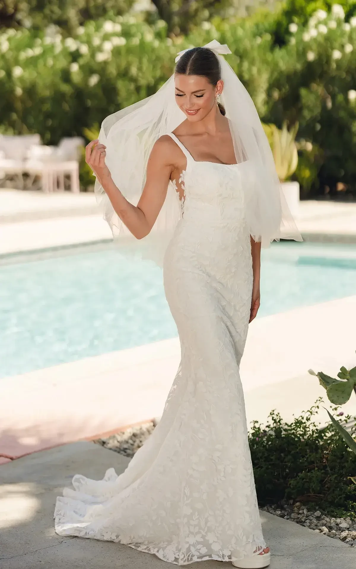 model is wearing a sleeveless lace wedding dress