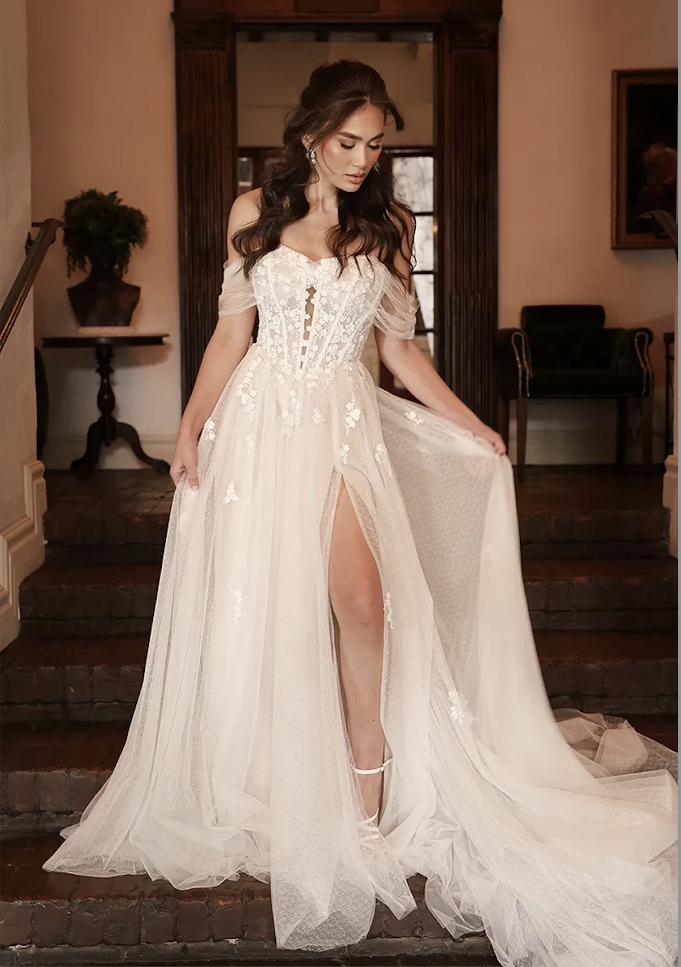 model is wearing an off the shoulder a-line wedding dress