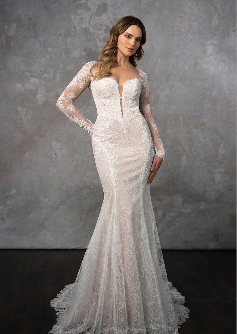model is wearing a long sleeve lace fit and flare wedding dress
